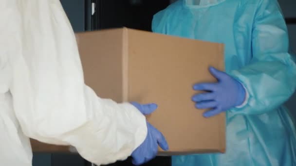 Entrega de equipo médico al hospital. Las personas con trajes protectores entregan cajas — Vídeos de Stock