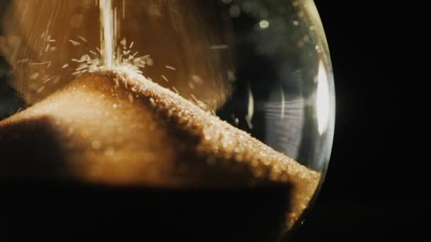 Slow motion video of Round hourglass flask where grains of sand fall — Stock Video