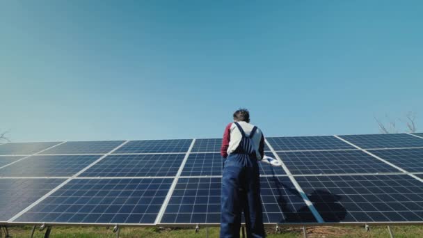 Rückansicht des Eigentümers wäscht Sonnenkollektoren im heimischen Kraftwerk — Stockvideo