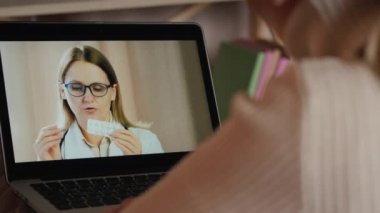 Kadın çevrimiçi doktorla görüşüyor. Karantina koşullarında bir doktorun video bağlantısı üzerinden danışmanlık