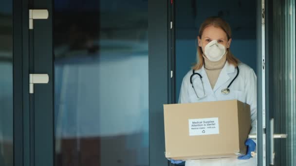 Kvinna läkare håller en låda med skyddande medicinska masker — Stockvideo