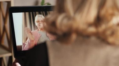Yaşlı bir kadın video aracılığıyla iletişim kuruyor, dizüstü bilgisayar kullanıyor.