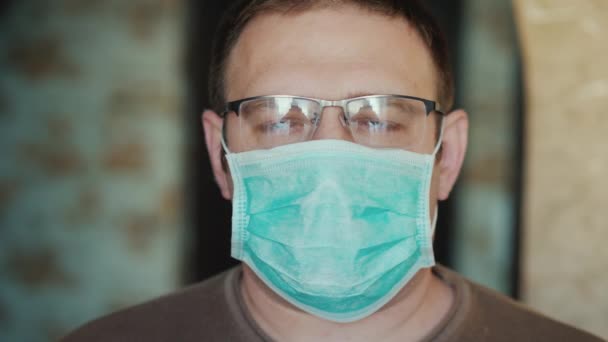 Egy középkorú férfi portréja orvosi maszkban. — Stock videók