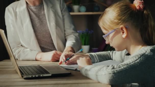 Femme aide l'enfant avec les devoirs, études de fille près de l'ordinateur portable — Video