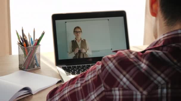 Mannelijke student die huiswerklessen neemt, online leert — Stockvideo