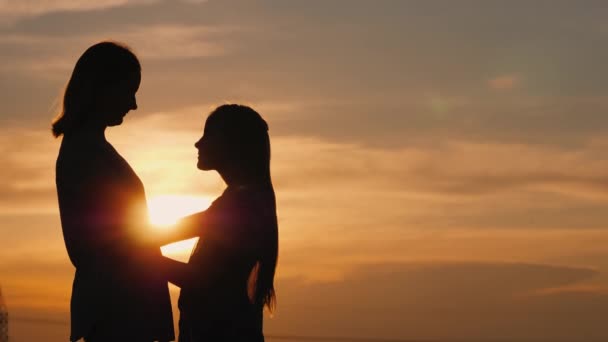 Silhouette of a young pensive woman at sunset looking into the distance — Stock Video