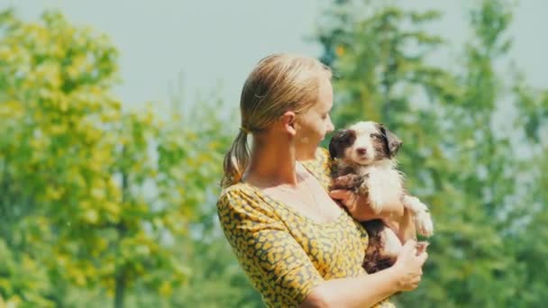 Yaz yağmurunda ıslanmış, yavru bir köpekle yetişkin bir kadının portresi. — Stok video