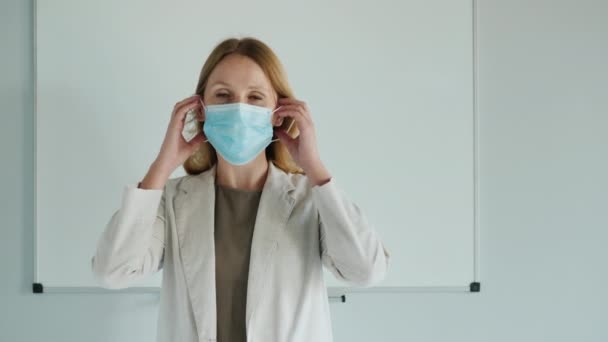 De leraar draagt een beschermend masker voor de klas — Stockvideo