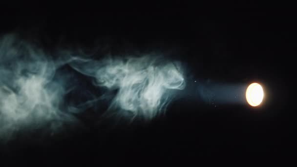 A flashlight beam illuminates the smoke on a black background — Stock Video