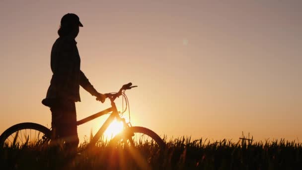 Kvinna med cykel beundrar solnedgången — Stockvideo