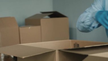 Gönüllü paketler bir karton kutuda konserve yiyecekler hazırlıyor.
