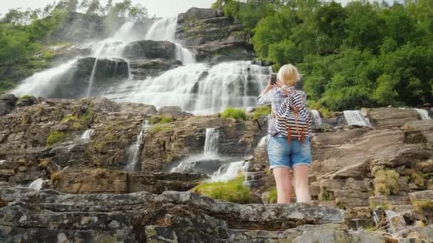 Steadicam lövés nő fényképek a legmagasabb vízesés Norvégiában. — Stock videók