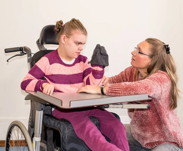 Un enfant handicapé en fauteuil roulant avec un travailleur bénévole — Photo