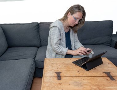 Ev onun dizüstü bilgisayar kullanarak bir orta yaşlı kadın