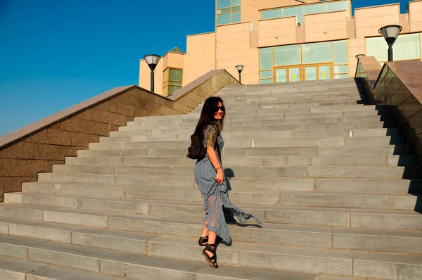 Mulher em uma rua da cidade sobe as escadas — Fotografia de Stock