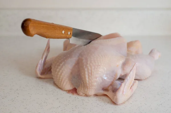 Carne de pollo cruda con cuchillo de trinchar — Foto de Stock