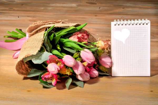 Ramo de tulipanes en la mesa con una nota —  Fotos de Stock