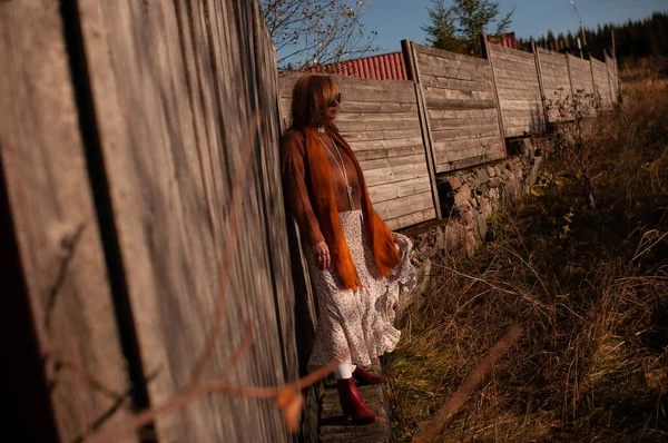 Chica rubia en una vieja cerca de madera — Foto de Stock