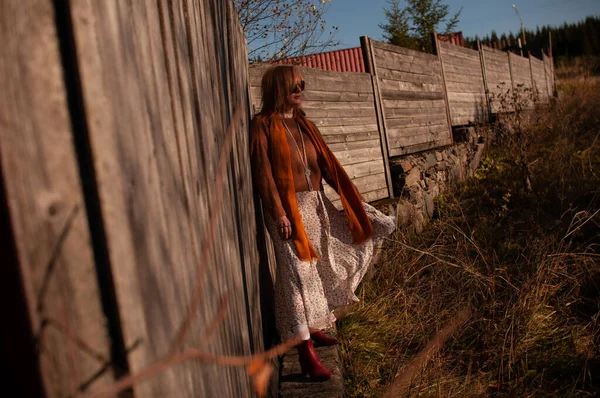 Chica rubia en una vieja cerca de madera — Foto de Stock