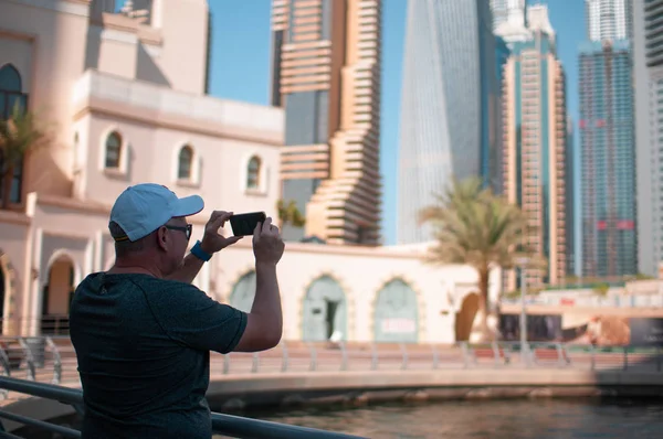 Men photographs the modern tall buildings of the city during — Stock Photo, Image