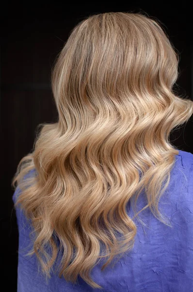 Long hair of a blonde woman with wave hairstyle