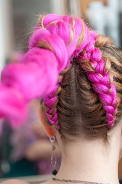 Bir kadının üzerinde kanekalon örülmüş renkli örgüler. Arkadan bak.