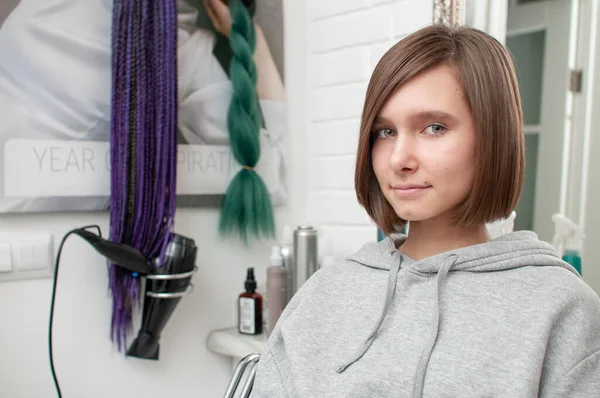 Haircut on a teenager girl in a beauty salon close-up