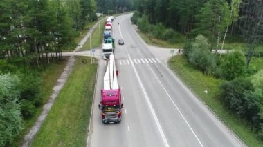    İnsansız bir kuadkopter, hareketsiz bir traktör kamyonu, rüzgar jeneratörü kargo taşımacılığı, karayolu, karayolu, üst görüntü, kamera hareketi olmadan.