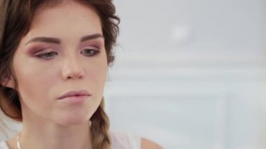 Bir fırçayla sol gözün makyajı. Makyöz çalışıyor. Dikkatlice bak. Kapatın. Bir fırçanın elinde. Bileziğin kolunda. Kız yüzü. Gözleri kapalı bir kız. Makyaj sanatçısı şık bir makyaj yapar..