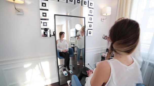 메이크업 아티스트걷기 모델은 의자에 있습니다 거울에 자신의 모습을 바라봅니다 카메라는 — 비디오