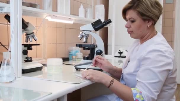 Eine Schöne Krankenschwester Nimmt Vorsichtig Ein Glas Mit Einer Probe — Stockvideo