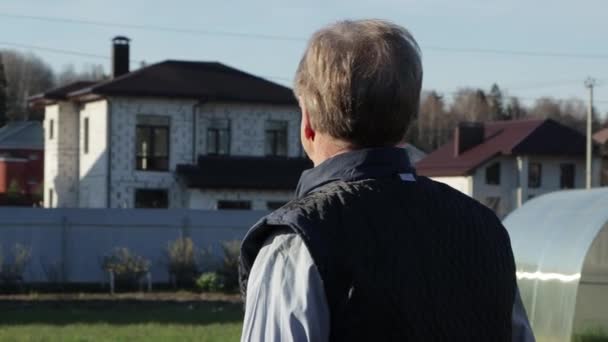 En man som står framför en byggnad — Stockvideo