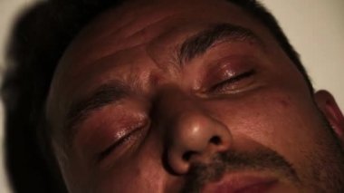 Erkeğin yüzü çok yakın. Yavaşça gözlerini açıyor..