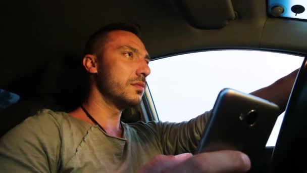 View from below a man in a car with a phone in his hand. — Stock Video