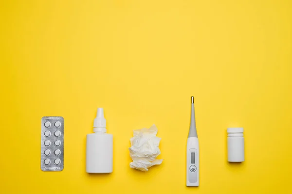 医療用温度計 鼻スプレーや組織 黄色の背景に異なる薬 風邪やインフルエンザの家庭の救済 病気の自己治療の概念 平置きだ テキストの空白のスペースを持つトップビュー — ストック写真
