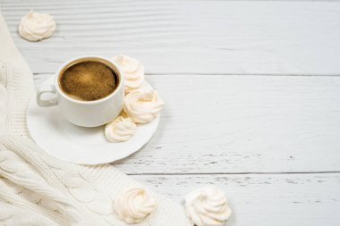 Beyaz tahtanın üzerinde krema olan beyaz bir fincan kahve. Boş alan. Sıcak içecek ve tatlı..
