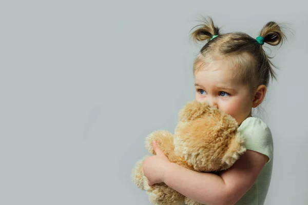 赤ん坊の幼児の肖像画は灰色の背景で離れて見て柔らかいおもちゃを保持する 子供の権利の概念 テキストのためのフリースペース — ストック写真