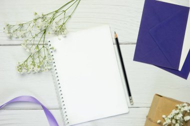 Beyaz ahşap zemin üzerinde kurşun kalem olan boş bir defter. Metin için boş alanı olan düz konum.