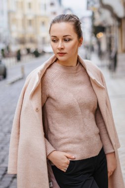 Pembe paltolu şık bir bayan şehirde dikilip poz veriyor.. 