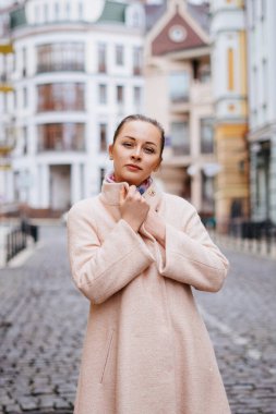 Şehirde dolaşan pembe paltolu güzel beyaz bir kadının açık hava portresi.. 