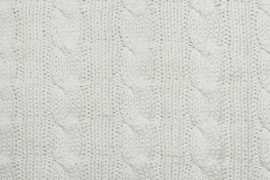 Örgü kumaş dokusu. Makine beyaz kumaştan örgü ördü. Dikey çizgili yün örülmüş battaniye arka planı.