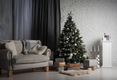 Kışın ev dekorasyonu. Çatı katındaki Noel ağacı tuğlaya karşı