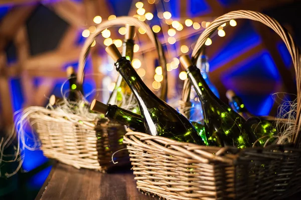 Champagne bottle set with Christmas basket, gold garlands on dar — Stock Photo, Image