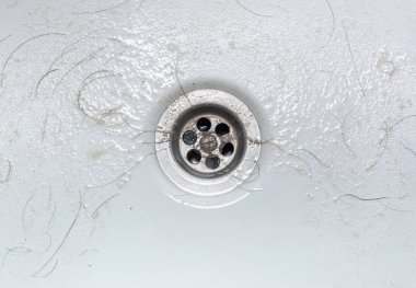 Kirli çamaşır leğeni kıllı kirli lavaboyu gösteriyor.