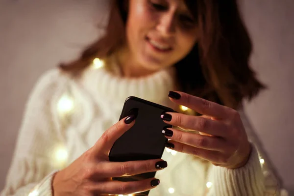 Brunette woman plays with garland of fairy light — Stock Photo, Image