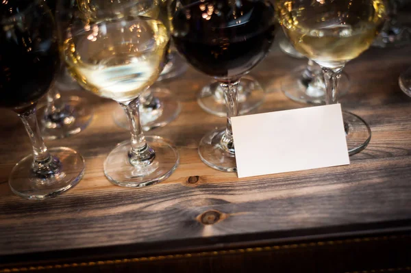 Glasses of wine on the bar with a neutral business car — Stock Photo, Image