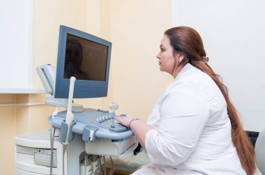 Doktor muayenehanede çayın üstünde oturuyor.