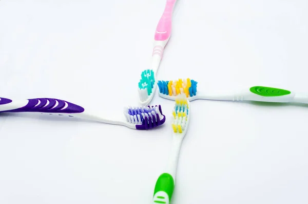 Різні зубні щітки на білому фоні — стокове фото