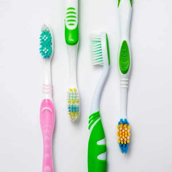 Forskellige tandbørster på en hvid backgroun - Stock-foto