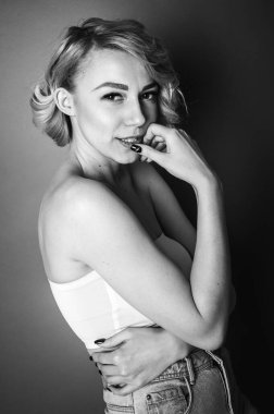 Genç, güzel sarışın soyunma odasında giyinmeye çalışıyor.